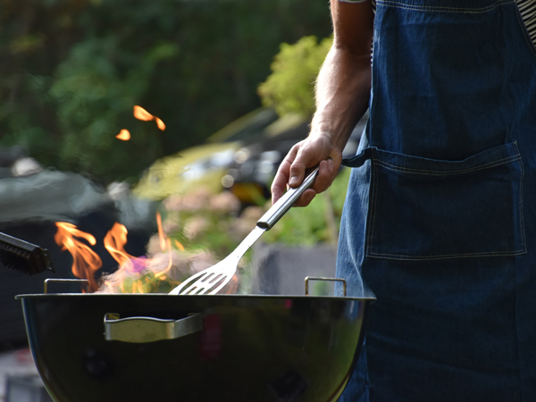 Man barbecuing outside in order to make his house cooler