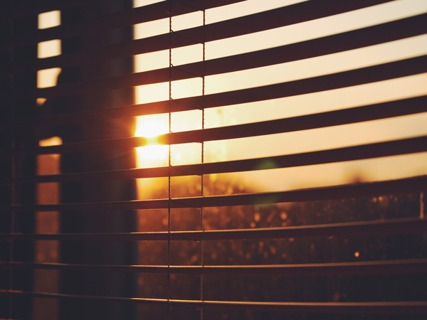 View of sun shining through blinds, keeping house cool
