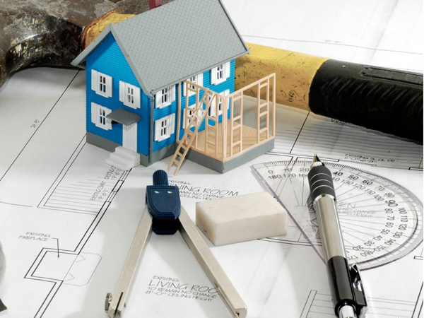 Mini house, protractor and pen used as planning for knocking down internal walls